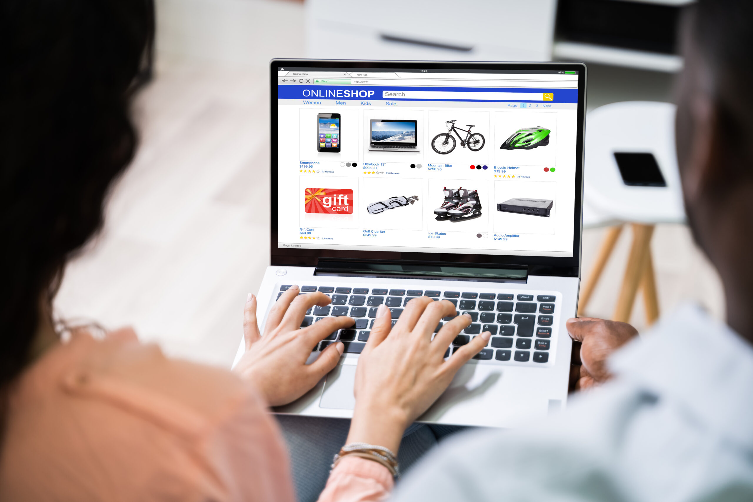 une personne assise devant son ordinateur portable surfe sur un site de vente en ligne