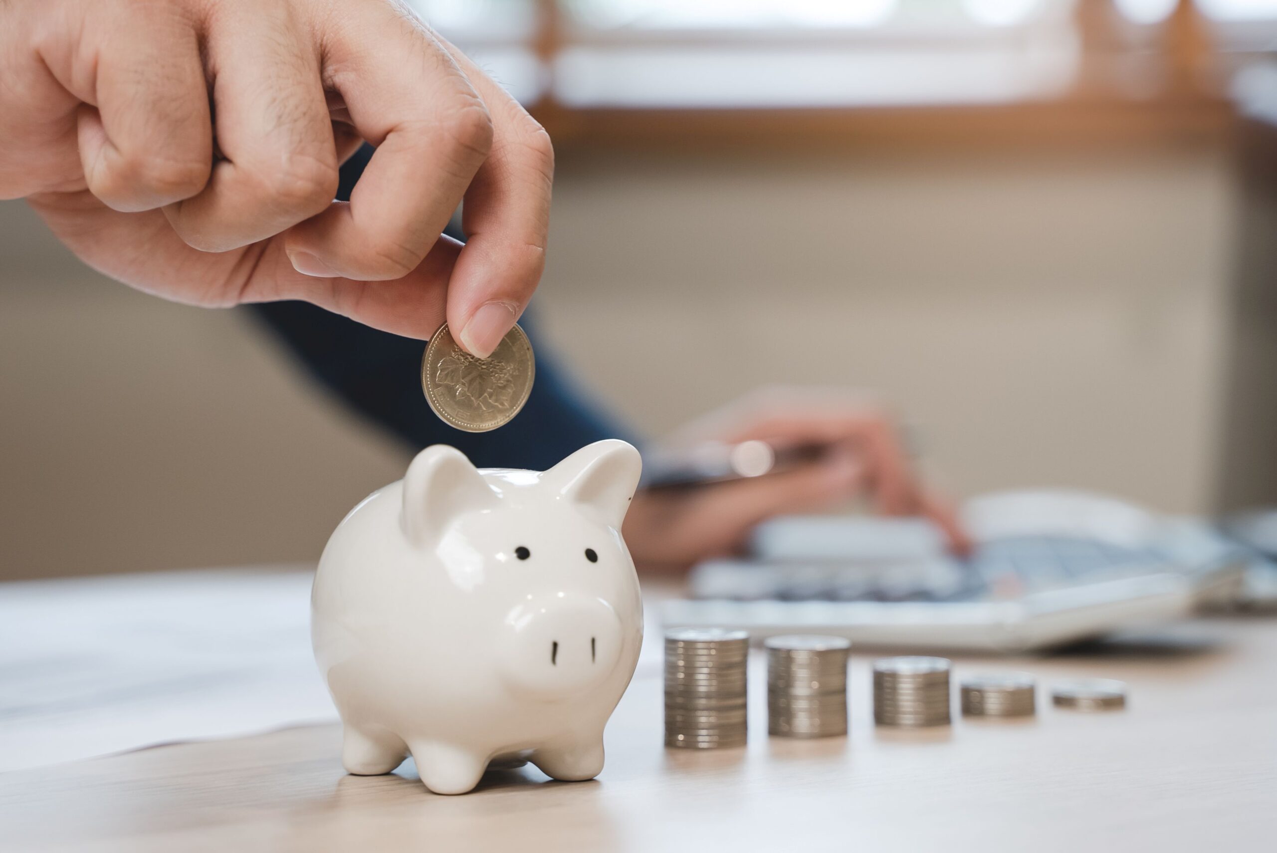 a person putting a coin into a piggy bank