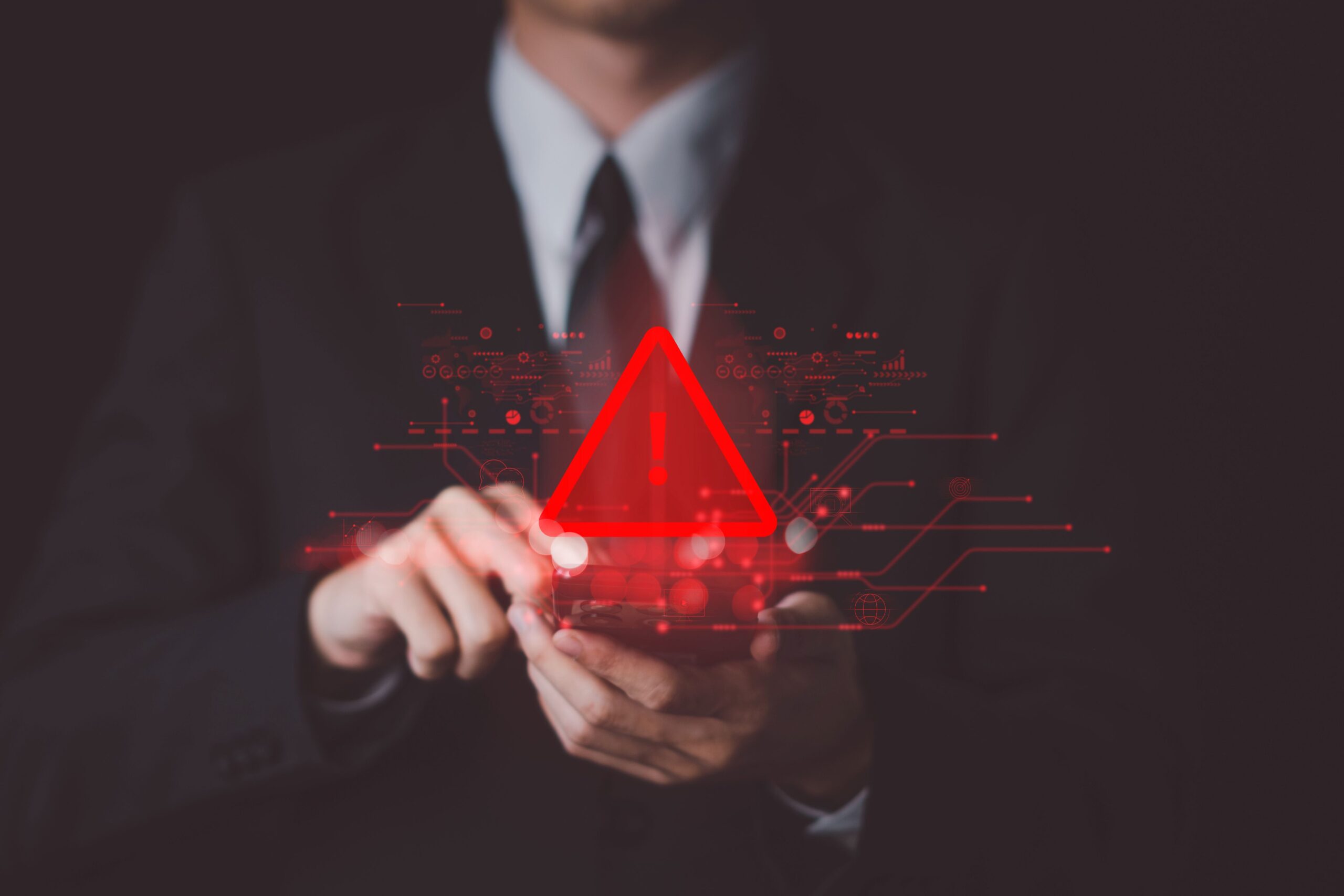 Un triangle rouge avec un point d'exclamation au centre au dessus d'un smartphone