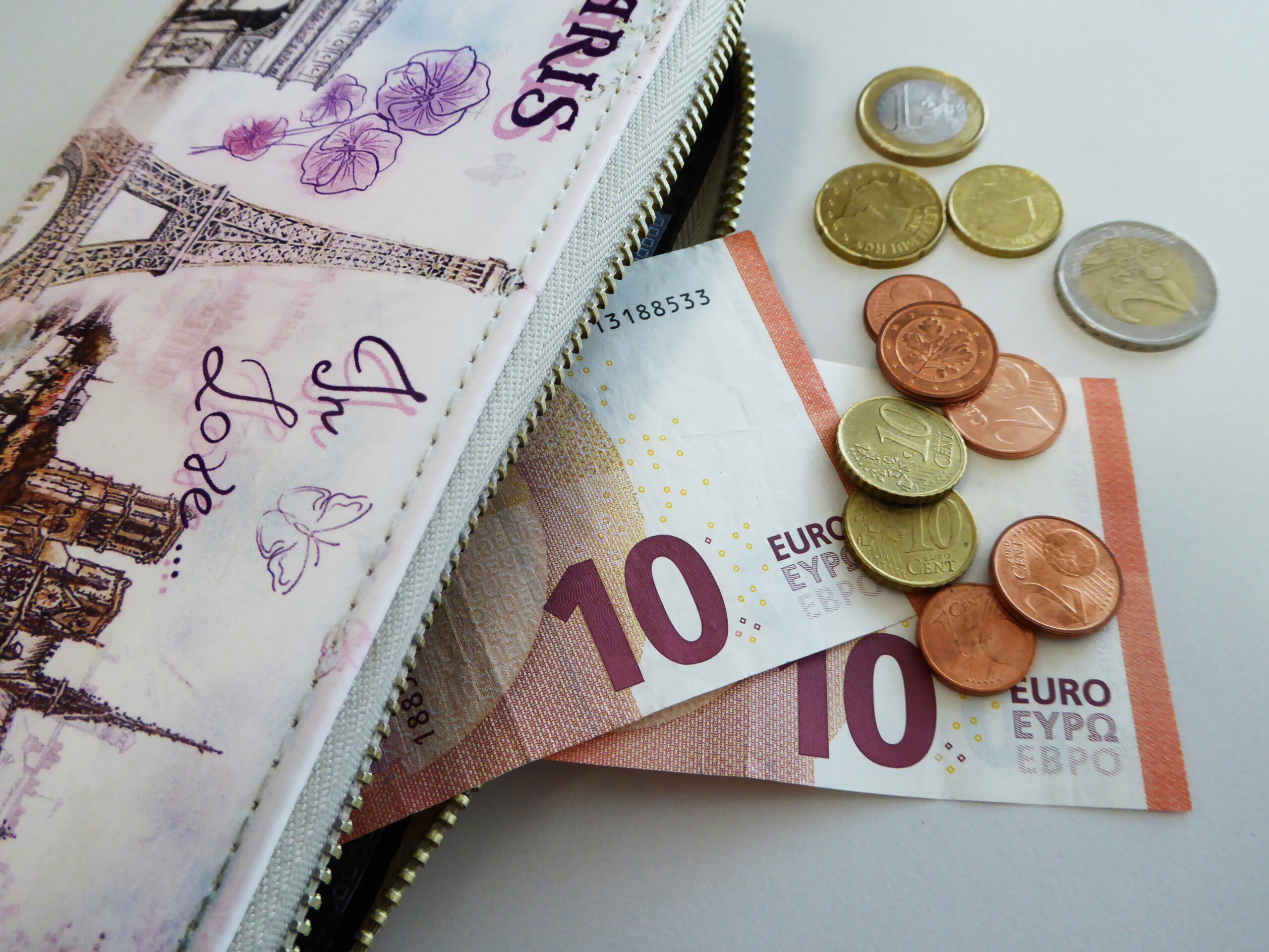 Vue sur un portefeuille duquel sort des billets et pièces de monnaie