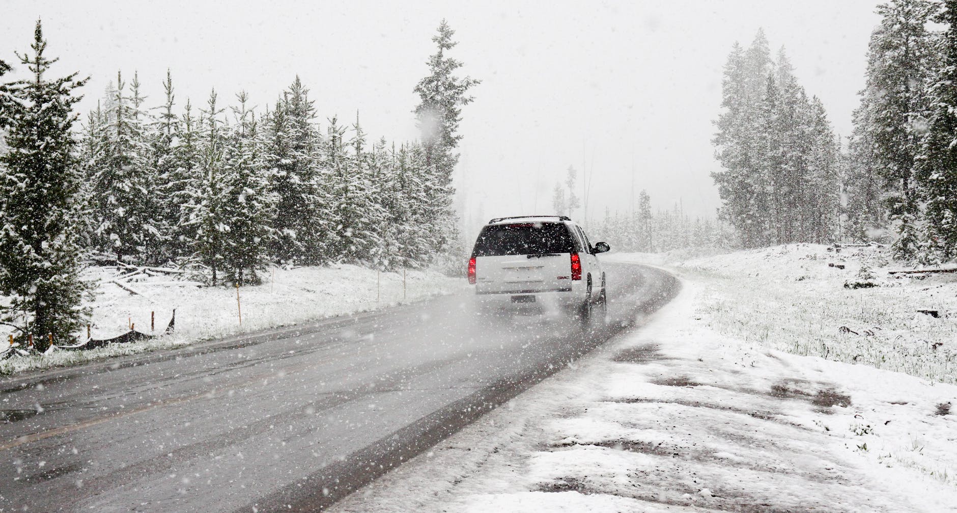 A white car driving in a snowy landscape
