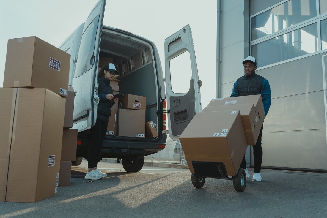 Two delivery drivers unloading parcels