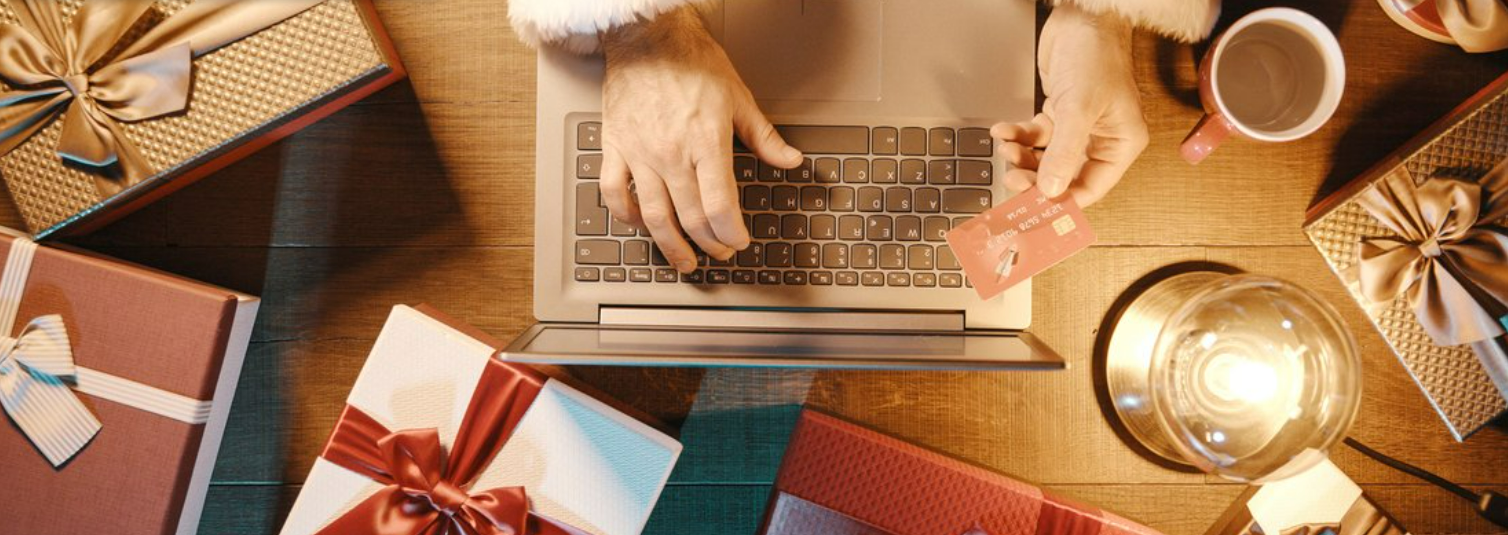 Homme entouré de cadeaux de noël avec sa carte de crédit