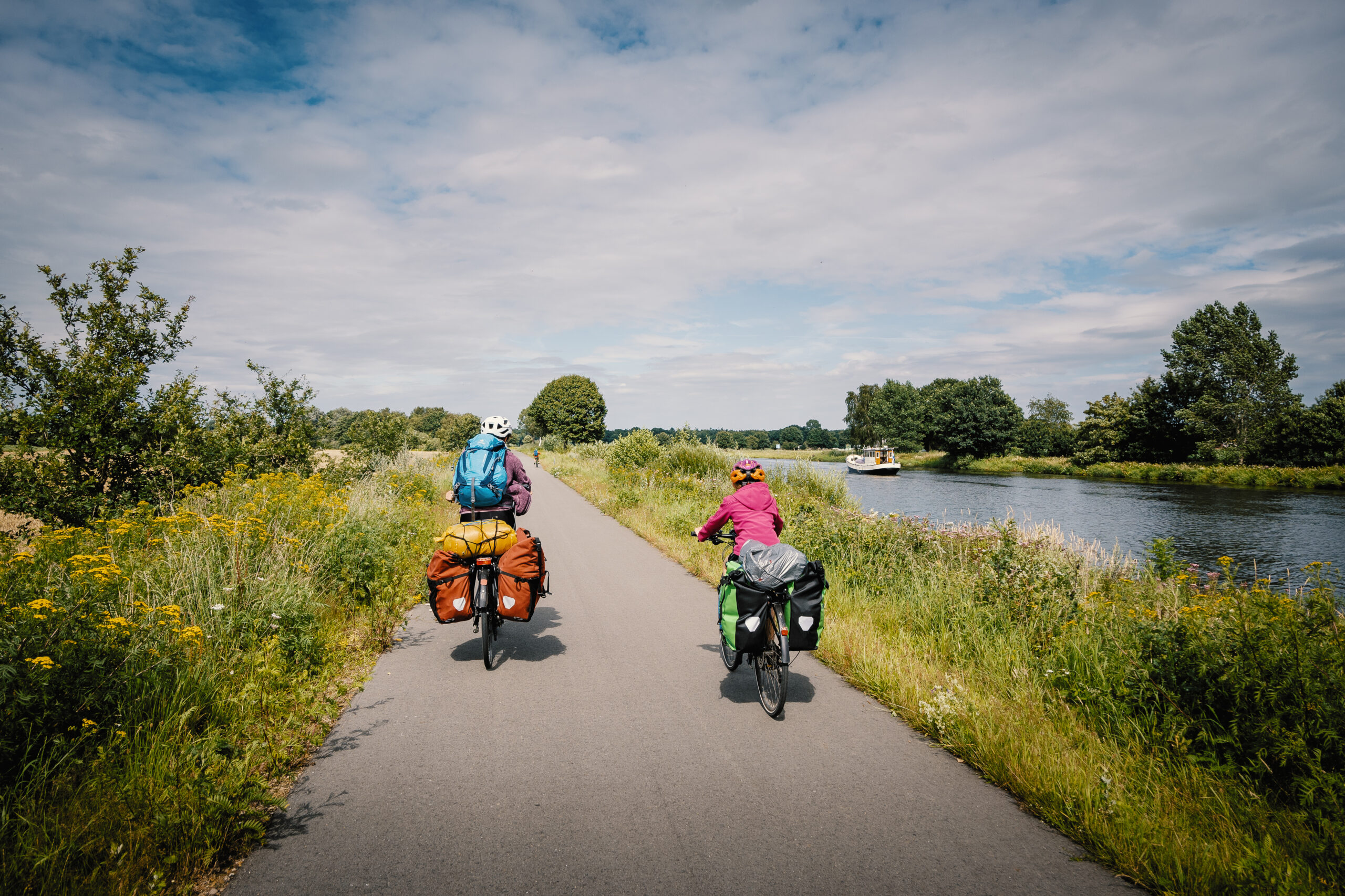 Deux touristes à vélo roulent le long d'un canal