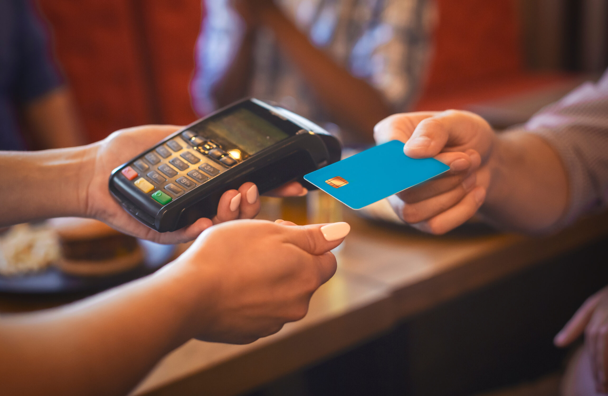 Serveuse caucasienne passant une carte bancaire dans un bar, concept de paiement rapide, image recadrée