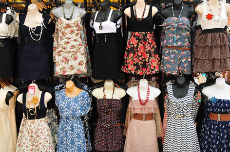 Colourful dresses exhibited on a market stall.