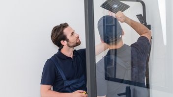 Deux hommes réparent un pommeau de douche