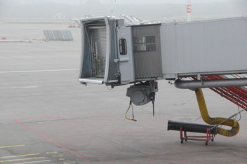 Unused boarding bridge on the tarmac of an airport.