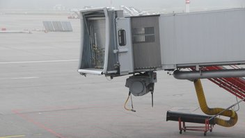 Passerelle d'embarquement inutilisée sur le tarmac d'un aéroport.