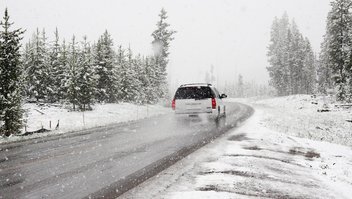 pneu-hiver-europe.jpg Une voiture roule sur une route au milieu d'un paysage enneigée.