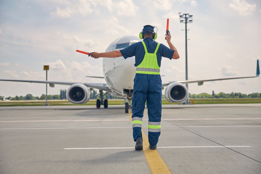 Personnel de l'aéroport signalise l'atterrisage d'un avion