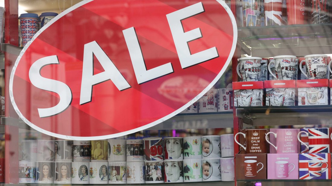 Une mention "soldes" est collée sur une vitrine de boutique de souvenirs.