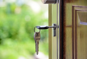 Close-up of a key in the lock of an entrance door.