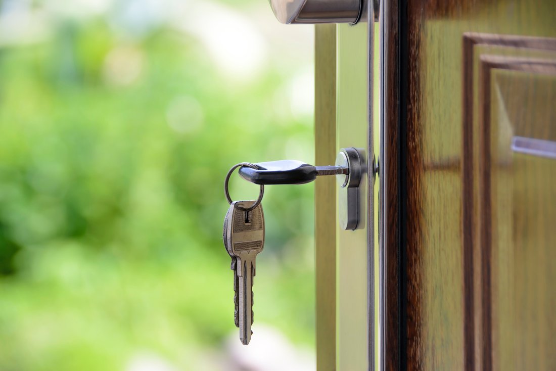 Close-up of a key in the lock of an entrance door.