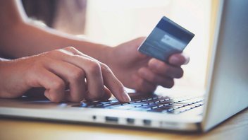 Une personne saisit les données de sa carte bancaire sur internet pour un paiement en ligne.