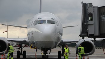 Un avion vu de face à l'arrêt sur la piste d'atterrissage, préparé par les techniciens de l'aéroport.